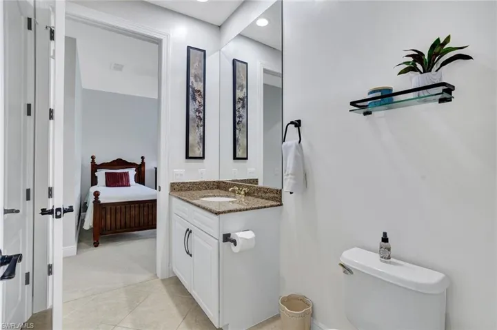 Ensuite bathroom featuring vanity, tile patterned floors, and recessed lighting