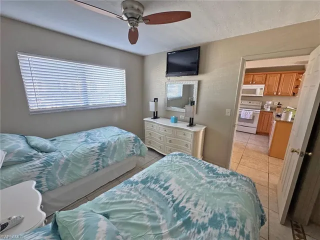 Guest Bedroom featuring light tile patterned floors and ceiling fan