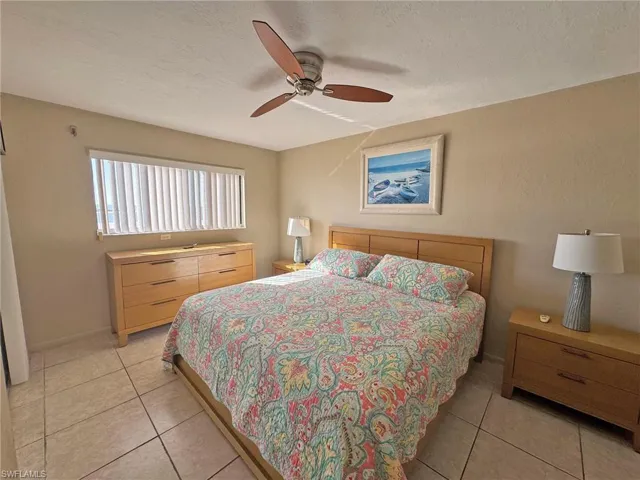 Master Bedroom featuring a ceiling fan, light tile patterned floors, and a textured ceiling