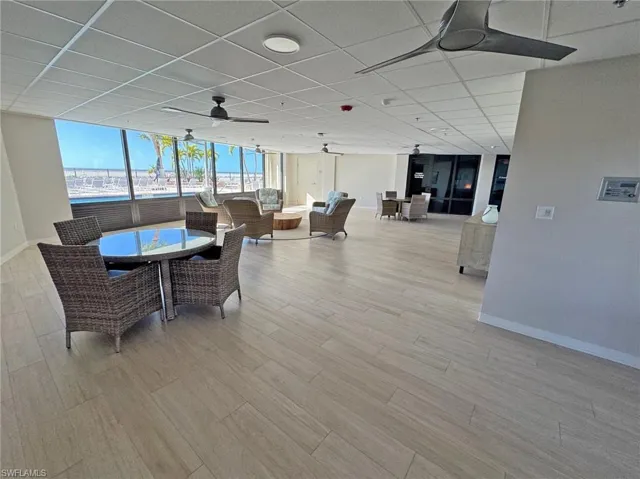 Common Rec room with ceiling fan, a paneled ceiling, and light wood-style floors