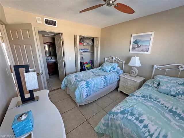 Tiled Guest bedroom featuring a closet and a ceiling fan