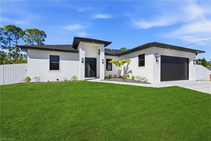 Prairie-style house featuring a gate, stucco siding, concrete driveway, and a garage