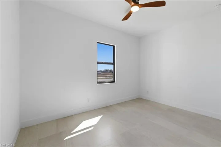 Empty room with baseboards and ceiling fan