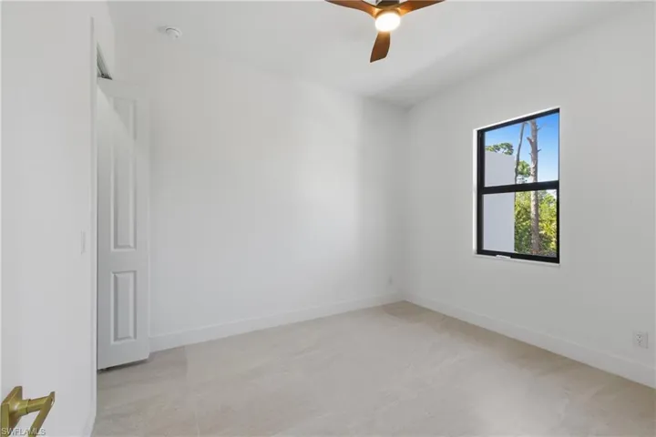 Empty room featuring a ceiling fan and baseboards