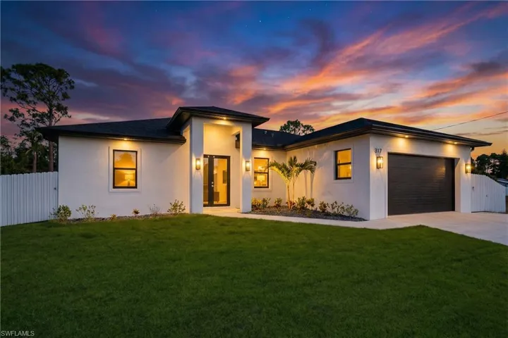 View of front of property featuring a gate, stucco siding, a garage, and concrete driveway