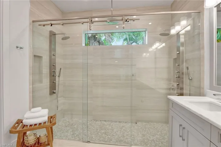 Full bath featuring a stall shower and vanity