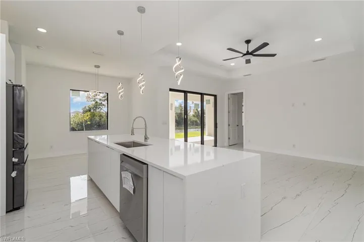Kitchen featuring modern cabinets, a sink, stainless steel dishwasher, recessed lighting, and open floor plan