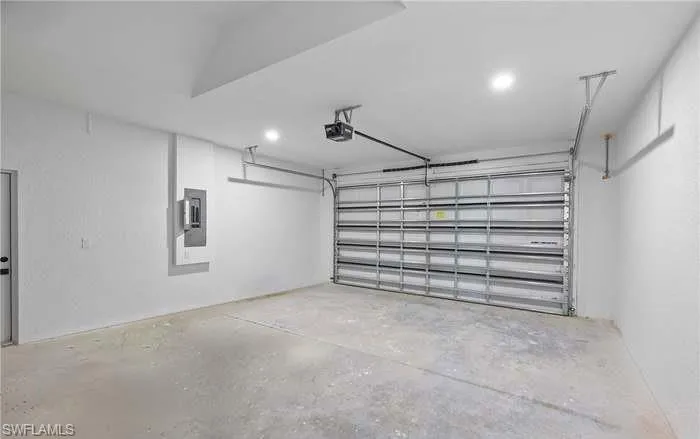 Garage featuring a garage door opener and electric panel
