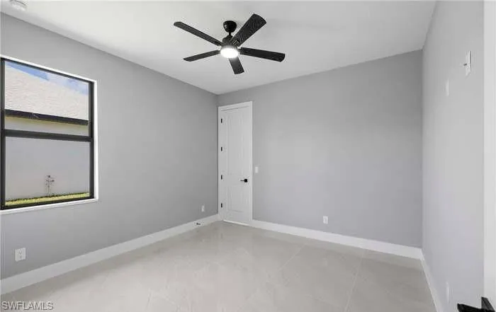 Tiled empty room with ceiling fan