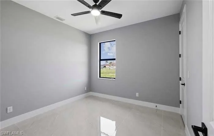 Spare room with ceiling fan and light tile patterned floors