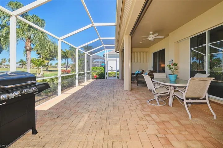 View of patio / terrace with a lanai, a sunroom, outdoor dining area, ceiling fan, and grilling area