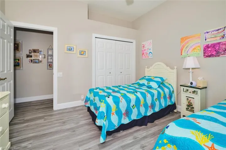 Bedroom featuring light wood-style floors, a closet, and a ceiling fan