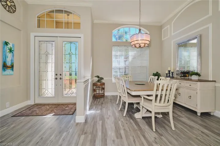 Dining space featuring french doors, light wood finished floors, and crown molding