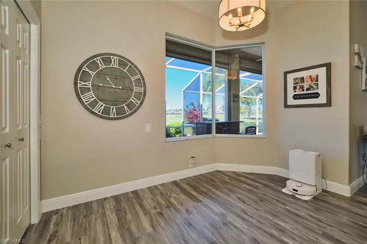Unfurnished dining area with baseboards and dark wood-style flooring