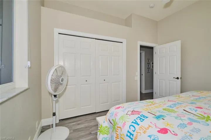 Bedroom with wood finished floors and a closet