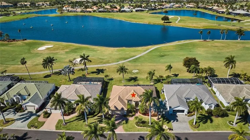 Aerial perspective of suburban area featuring a large body of water and a local golf course
