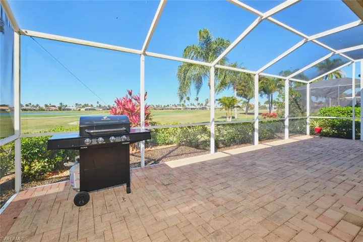 Sunroom / solarium featuring view of golf course and a patio area
