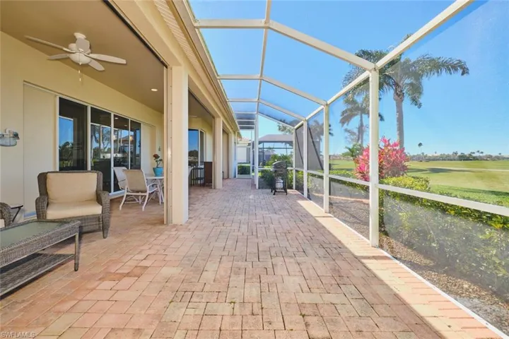 Sunroom with ceiling fan and a patio
