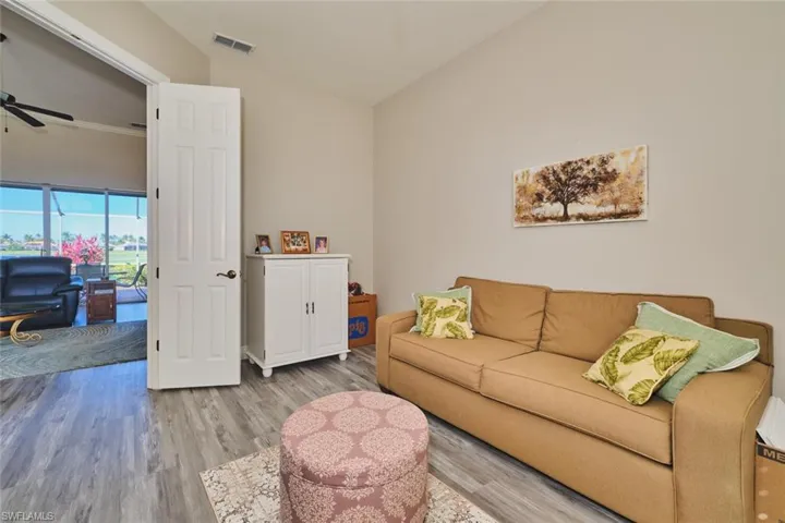 Living area featuring wood finished floors, a ceiling fan, and lofted ceiling