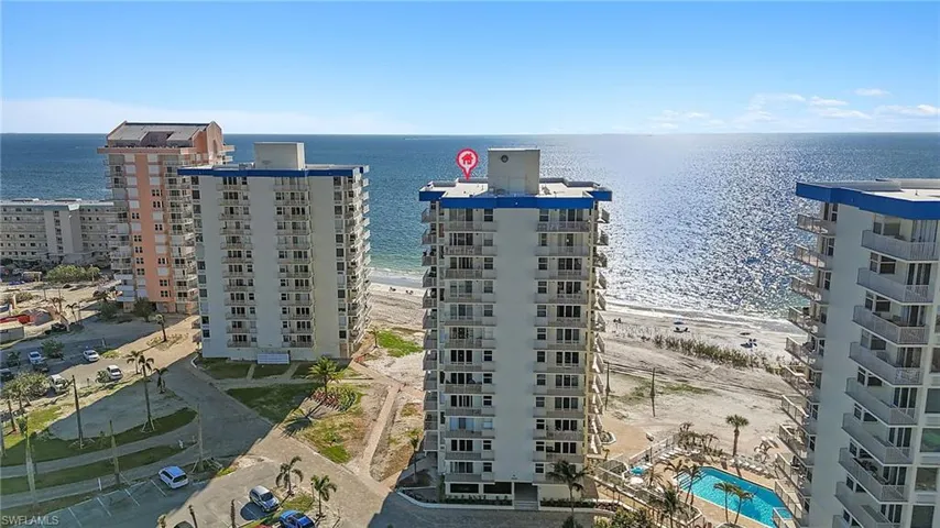 Birds eye view of property featuring a water view and a beach view