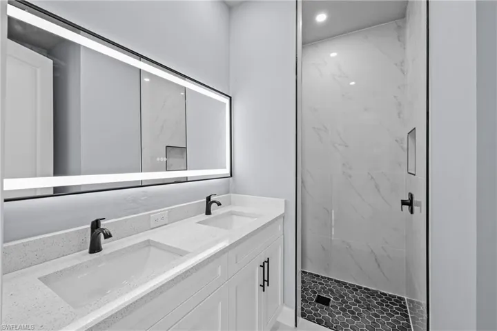 Bathroom featuring vanity and a tile shower