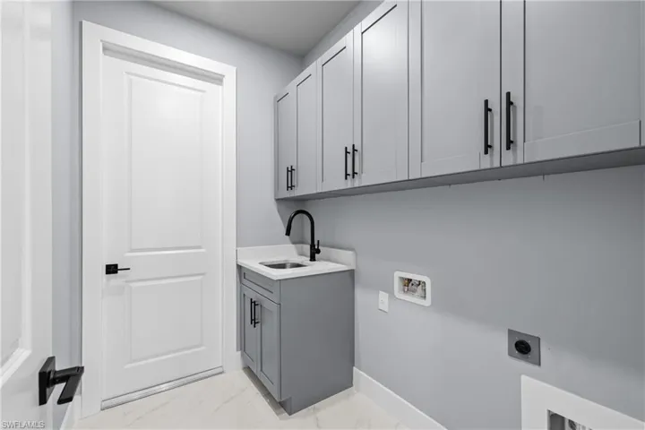 Laundry room featuring cabinets, hookup for a washing machine, sink, and electric dryer hookup