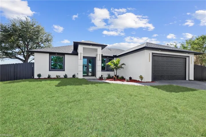 View of front of home featuring a garage and a front yard