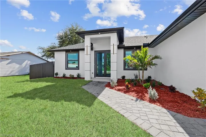Doorway to property with a lawn