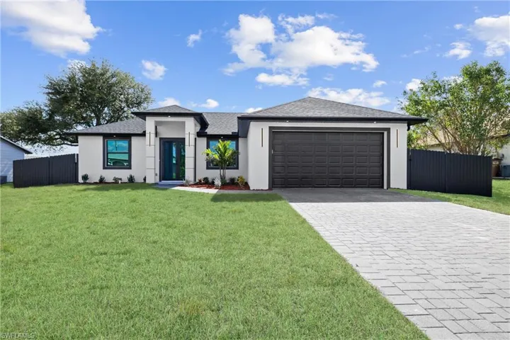 View of front of property featuring a garage and a front yard