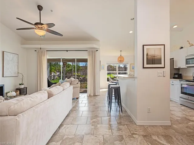 Living area featuring a ceiling fan, light stone finish flooring, and recessed lighting