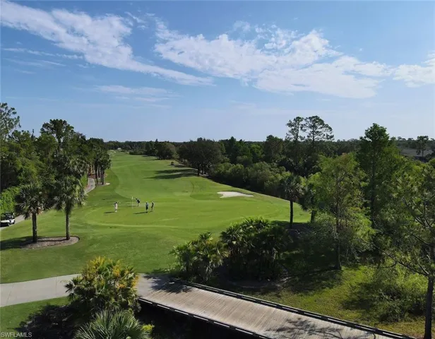 View of property's community with view of golf course and view of wooded area