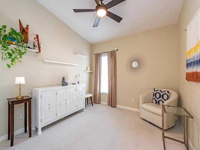 Sitting room featuring vaulted ceiling, light colored carpet, and a ceiling fan