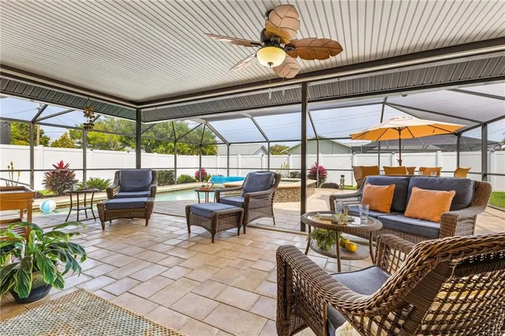 Fenced backyard featuring an outdoor lounge area, glass enclosure, and a sunroom