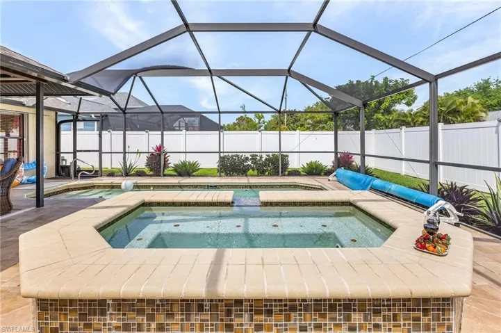 View of swimming pool featuring an in-ground hot tub, a fenced backyard, a sunroom, and a lanai