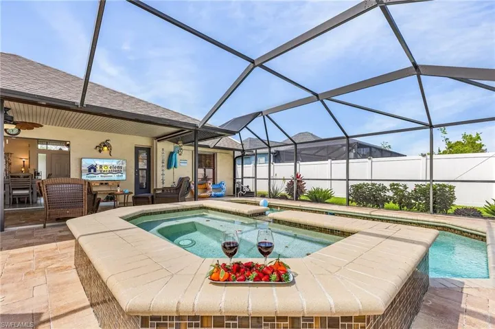 View of pool with a sunroom, an in-ground hot tub, a lanai, and patio surround