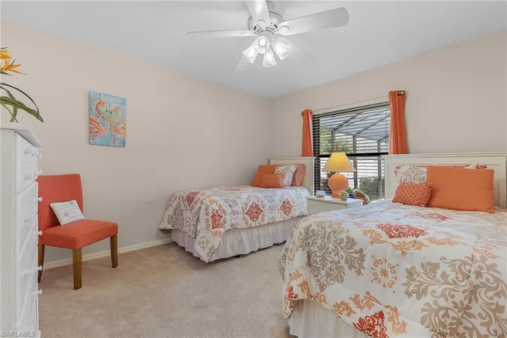 Carpeted bedroom featuring ceiling fan and baseboards