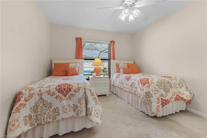 Bedroom with ceiling fan and light colored carpet