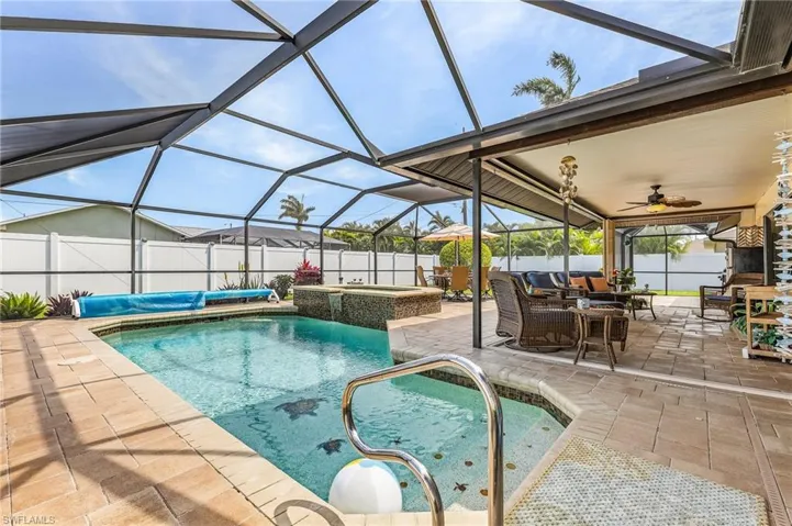 View of pool featuring a lanai, a sunroom, patio surround, and a fenced backyard