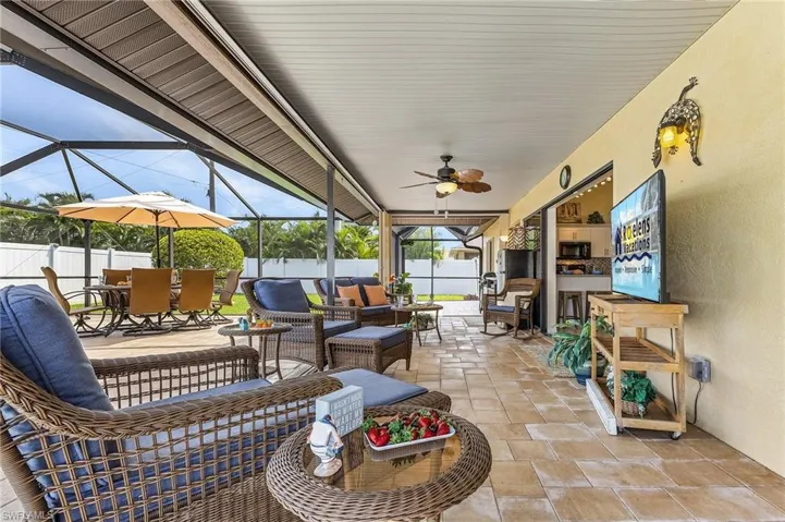 View of patio with a sunroom, glass enclosure, outdoor lounge area, and a ceiling fan