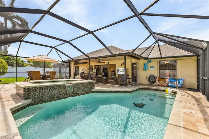 Combined pool / hot tub with outdoor dining area, a sunroom, a patio, and glass enclosure