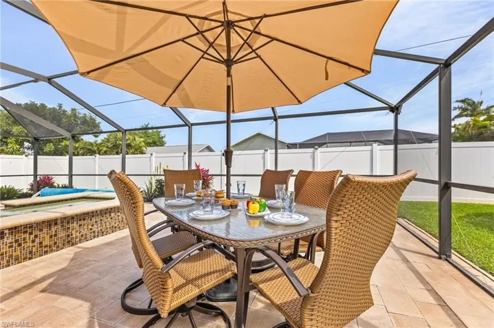 Fenced backyard with a lanai, a sunroom, outdoor dining area, and a patio area