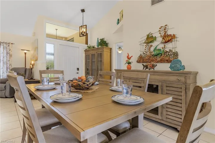 Dining space featuring a high ceiling, light tile patterned floors, and suspended lighting