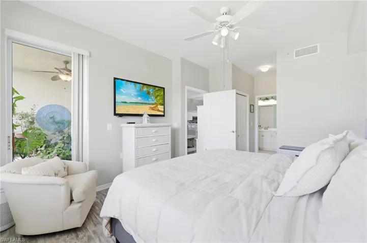 Spacious room featuring wood-finish flooring, a ceiling fan with integrated lighting, and a sliding glass door to an outdoor area