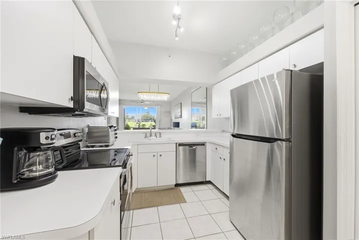 Kitchen featuring white cabinetry, white countertops, stainless steel appliances, and tile flooring