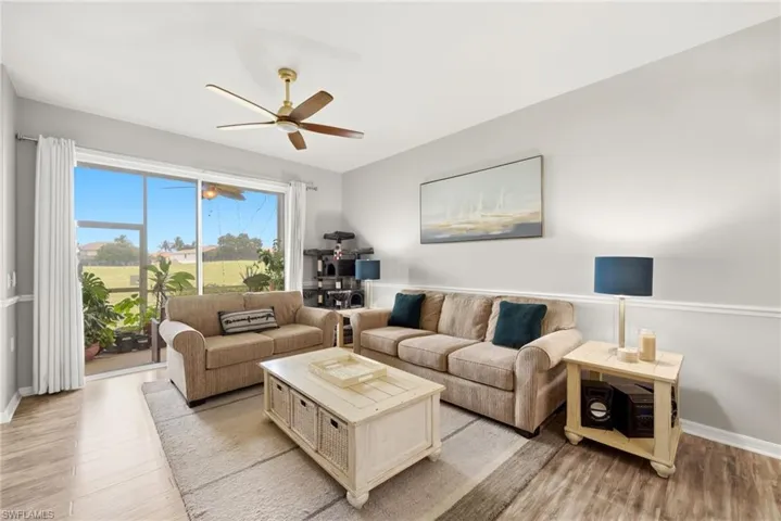 Living area featuring wood-finish flooring, a ceiling fan, and sliding glass doors to the exterior