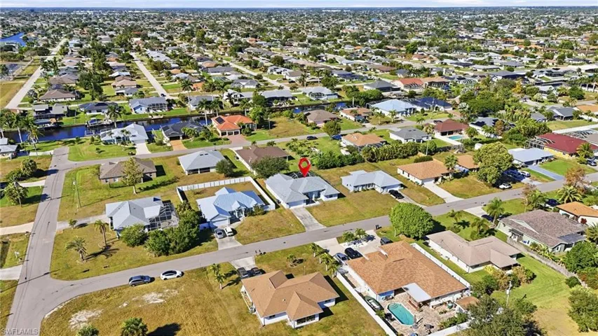 Aerial view of property and surrounding area featuring nearby suburban area