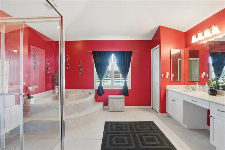 Bathroom with a garden tub, vanity, light tile patterned flooring, and a stall shower