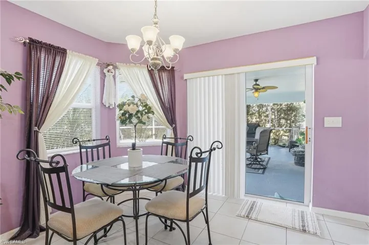 Dining area featuring a chandelier, healthy amount of natural light, tile patterned floors, and ceiling fan