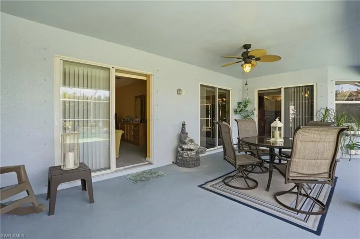 View of patio with outdoor dining area and a ceiling fan
