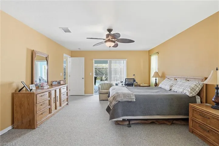 Bedroom with light colored carpet, a ceiling fan, and access to outside